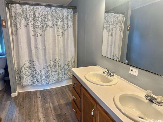 Full bath featuring toilet, double vanity, shower / tub combo with curtain, and ornamental molding | Image 18