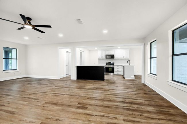 Unfurnished living room featuring wood finished floors, ceiling fan, recessed lighting, and baseboards | Image 8