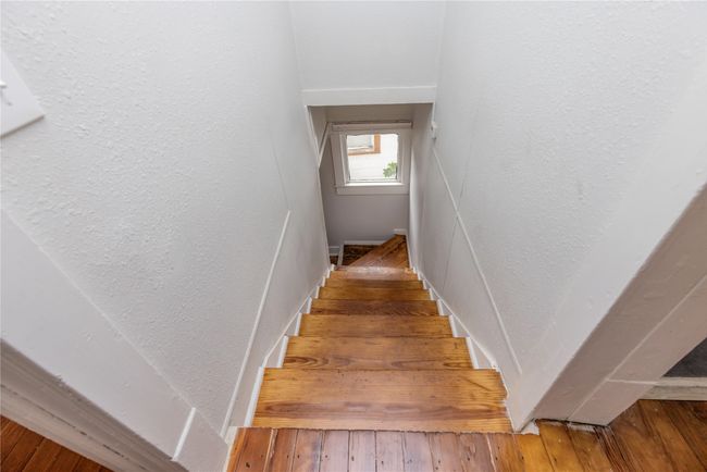 Staircase with a textured wall and hardwood / wood-style flooring | Image 24