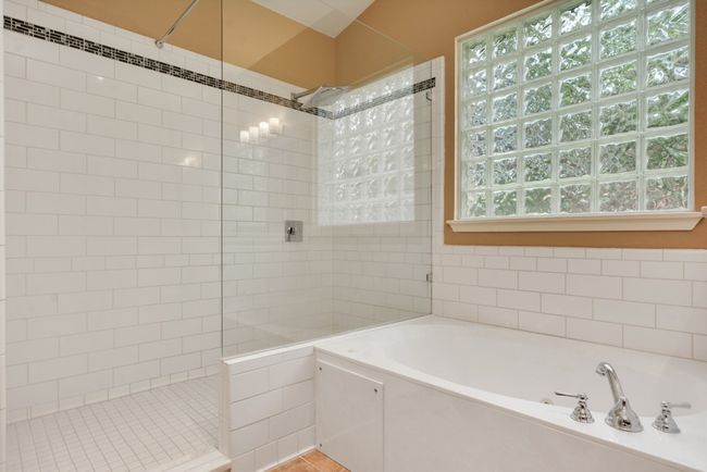 The spacious primary suite is a true retreat, complete with a luxurious bath featuring dual vanities, a walk-in shower, a soaking tub, and an oversized walk-in closet. | Image 25