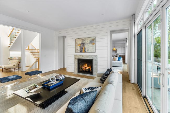 Living area featuring stairs, a fireplace, and light wood finished floors | Image 13
