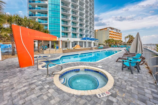 Community pool featuring a patio area, a hot tub, and fence | Image 24