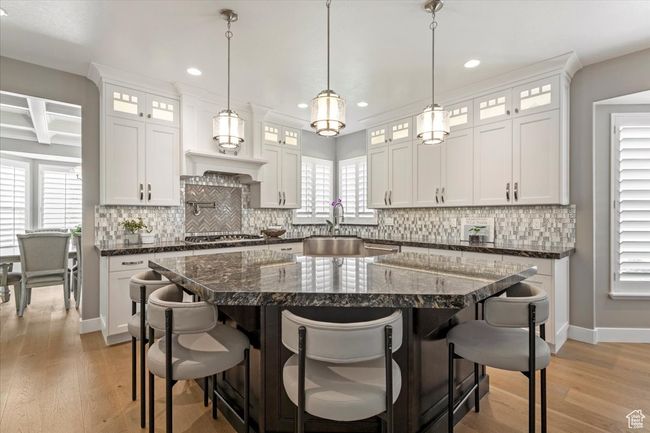 Kitchen featuring a sink, a breakfast bar, light wood finished floors, recessed lighting, and baseboards | Image 10