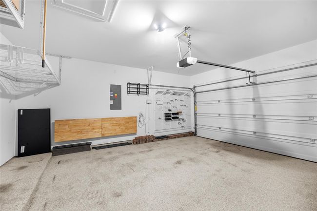 This garage features Polyurea coated flooring with ample storage options, including overhead racks and wall organizers. | Image 23