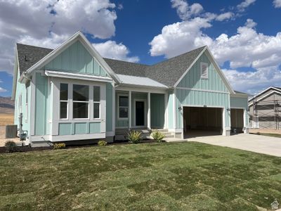 View of front of house featuring a garage, a front lawn, central AC, and covered porch | Image 1