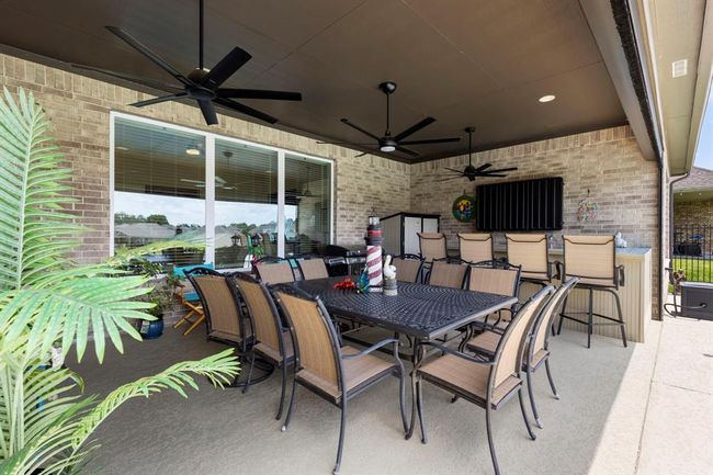 Experience outdoor living on the spacious covered porch, complete with a retractable screen, built-in bar, and sink for effortless entertaining. | Image 4