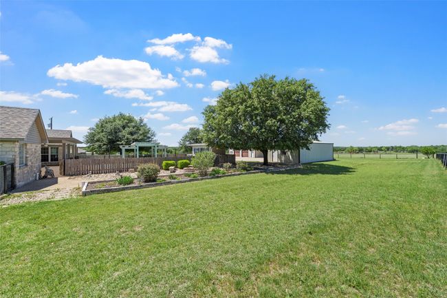 View of yard with fence, a pergola, and an outbuilding | Image 33