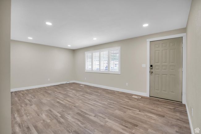 Interior space featuring visible vents, baseboards, recessed lighting, and wood finished floors | Image 8