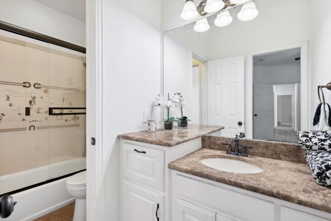 Full bath featuring vanity, shower / bath combination with glass door, and toilet | Image 22