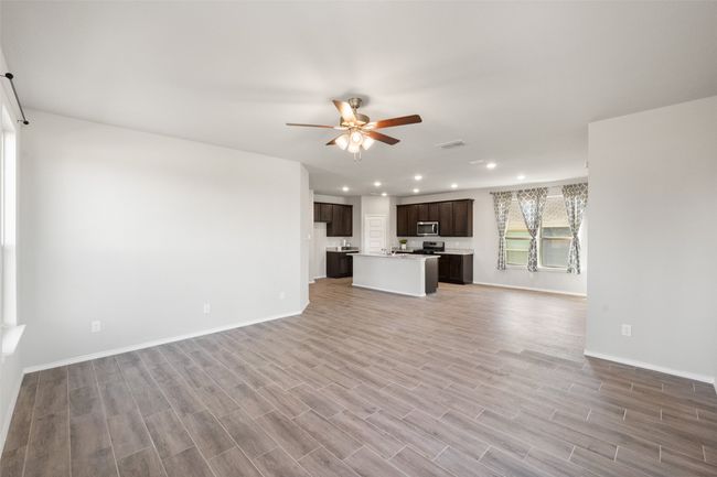 Unfurnished living room with light wood-style flooring, baseboards, visible vents, ceiling fan, and recessed lighting | Image 5