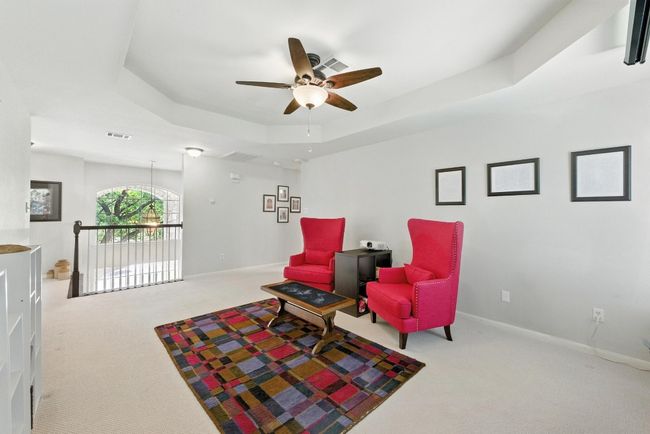 Living area featuring carpet flooring, a tray ceiling, and ceiling fan | Image 16
