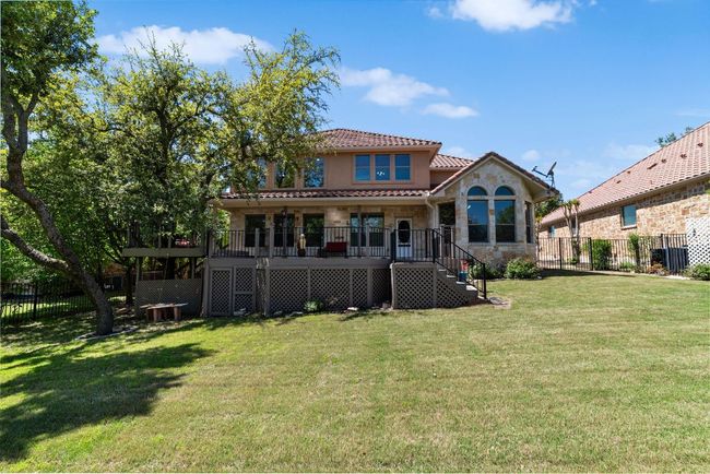 Rear view of property with a tiled roof, stone siding, stairs, and stucco siding | Image 28