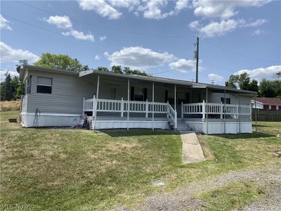 Manufactured / mobile home featuring a porch and a front lawn | Image 1