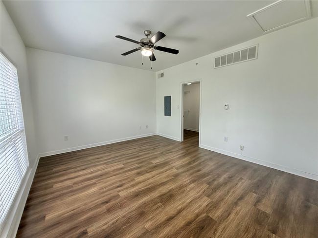 Spare room with dark wood-type flooring, a ceiling fan, baseboards, and electric panel | Image 12