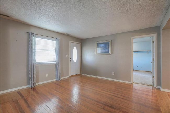 Entrance foyer featuring baseboards, a textured ceiling, visible vents, and hardwood / wood-style flooring | Image 36