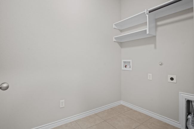 Laundry area featuring laundry area, baseboards, electric dryer hookup, washer hookup, and light tile patterned floors | Image 21