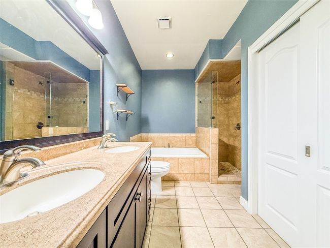 Full bath with a stall shower, a garden tub, light tile patterned floors, and double vanity | Image 16