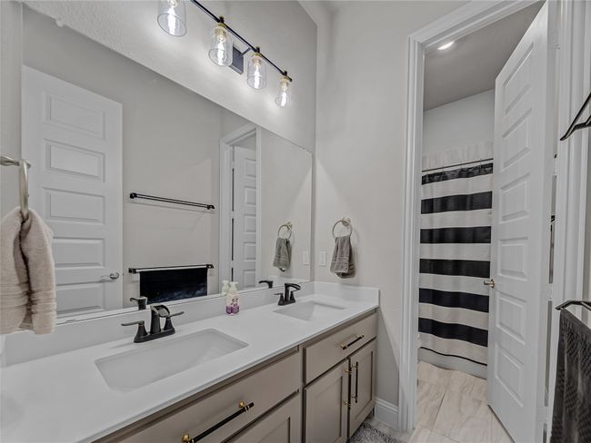 Bathroom featuring double vanity, marble finish flooring, and curtained shower | Image 30