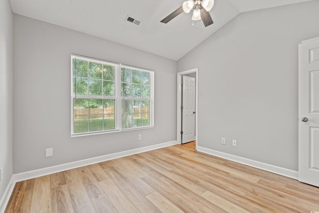 Empty room featuring a ceiling fan, vaulted ceiling, and light wood-style floors | Image 16
