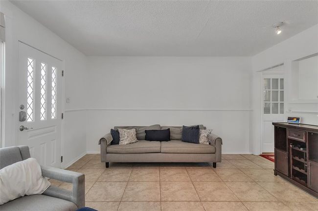 Living area featuring a textured ceiling and light tile patterned flooring | Image 5