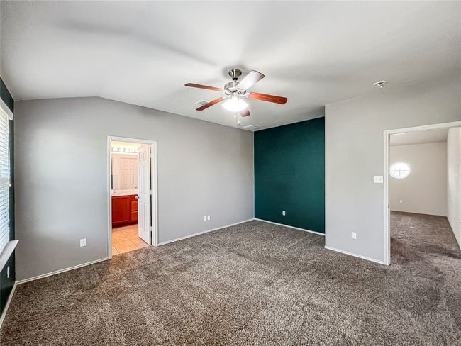 Unfurnished bedroom featuring light colored carpet, a ceiling fan, and lofted ceiling | Image 20