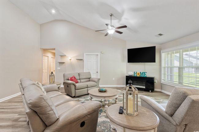 Living area featuring light wood finished floors, ceiling fan, and high vaulted ceiling | Image 10