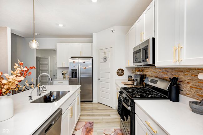 kitchen with white cabinets, appliances with stainless steel finishes, light countertops, and a sink | Image 9