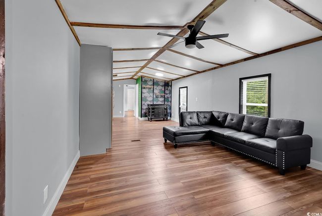 Living area with ceiling fan, light wood finished floors, and baseboards | Image 21