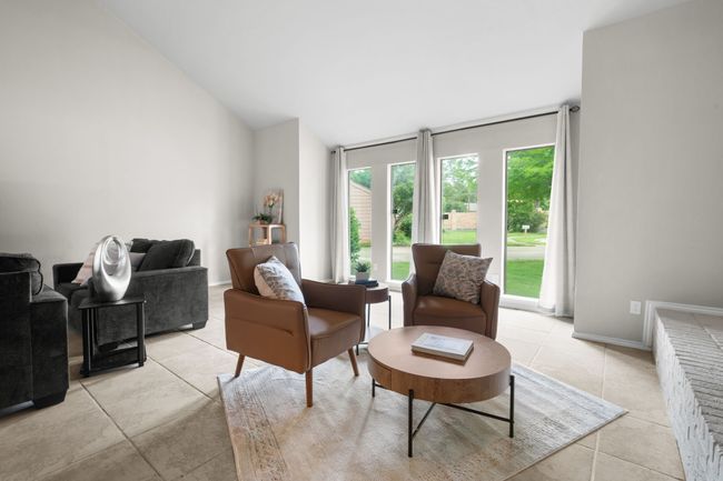 Living area with light tile patterned floors, high vaulted ceiling, and baseboards | Image 29