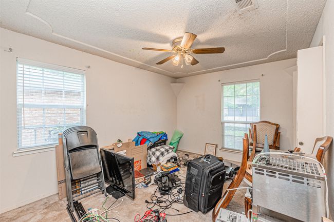Misc room featuring a textured ceiling, visible vents, a ceiling fan, and carpet floors | Image 12