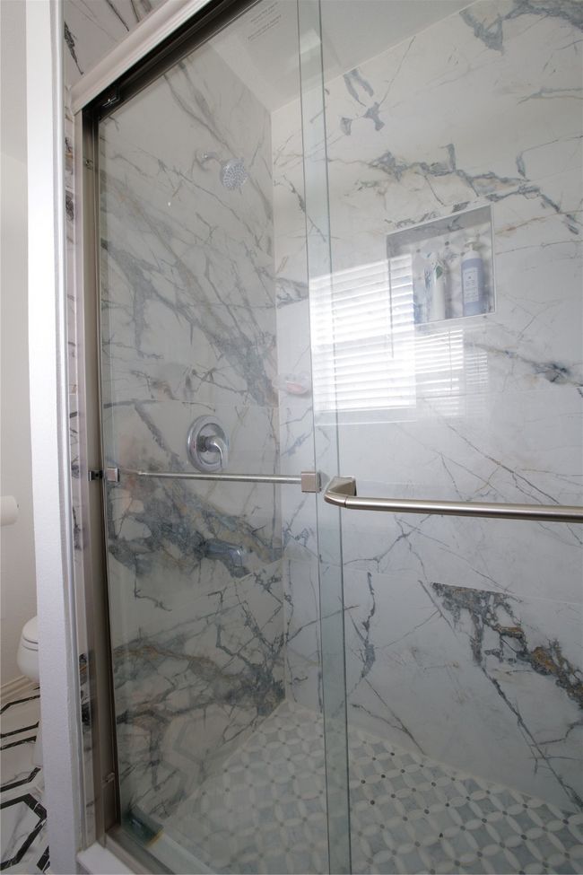 Bathroom with toilet and a marble finish shower | Image 25