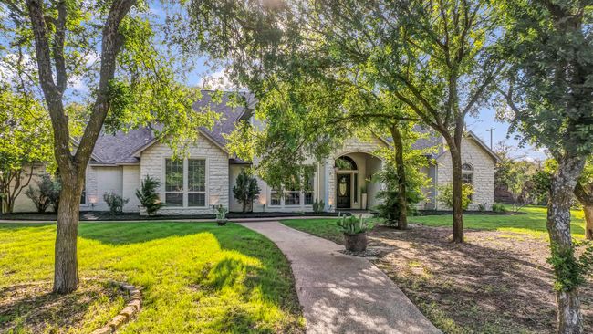 View of front of house featuring a front lawn, stone siding, and roof with shingles | Image 36