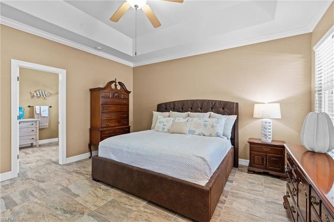 Bedroom featuring a tray ceiling, ornamental molding, ceiling fan, and baseboards | Image 25