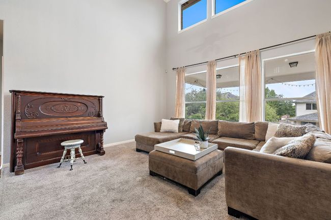 The living room is bright and open with fresh paint throughout, a gas fireplace, 2-story ceilings, and opens to the kitchen and breakfast nook. It also overlooks the beautiful backyard! | Image 15
