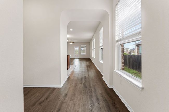 Hallway with dark wood-style flooring and arched walkways | Image 5