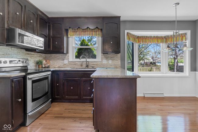 Kitchen features stone counters, SS appliances, hardwood floors and separate pantry | Image 11