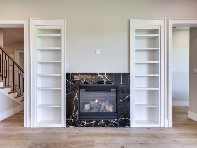 Detailed view of baseboards, built in features, wood finished floors, and a fireplace | Image 17