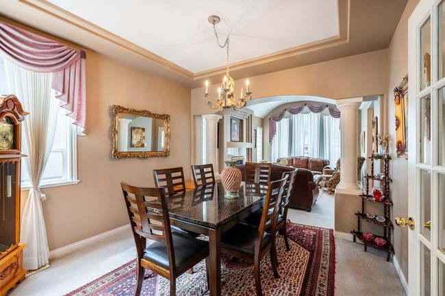 Dining space with decorative columns, a raised ceiling, and arched walkways | Image 11