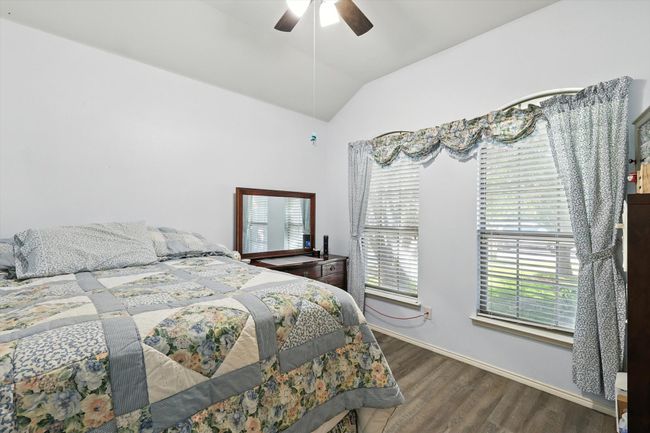 Bedroom featuring vaulted ceiling, wood finished floors, and a ceiling fan | Image 12