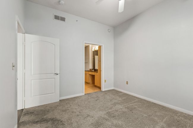 Unfurnished bedroom featuring carpet flooring, ensuite bath, and ceiling fan | Image 22