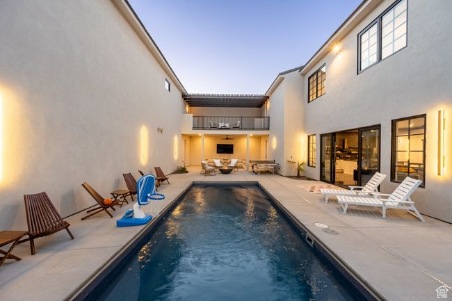 Pool at dusk with an outdoor hangout area, ceiling fan, and a patio | Image 26