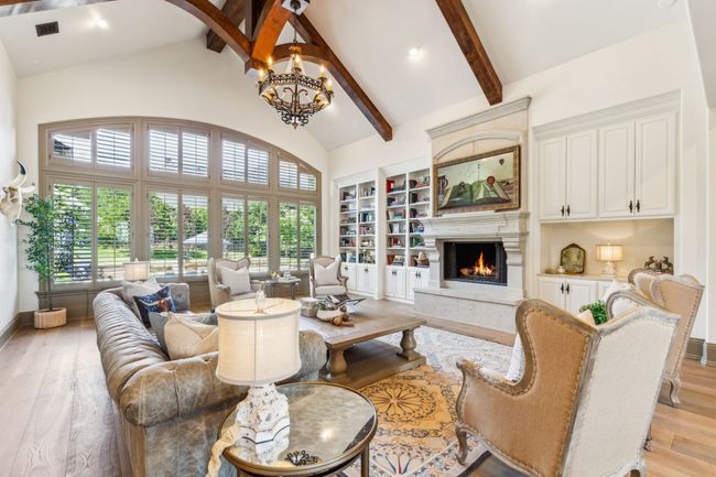 The Living Room Features Soaring Ceilings with Striking Wood Beams | Image 7