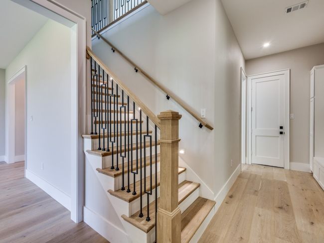 Stairway with wood finished floors, baseboards, and recessed lighting. Stairway lighting with auto sensors to light up your way on the steps | Image 29