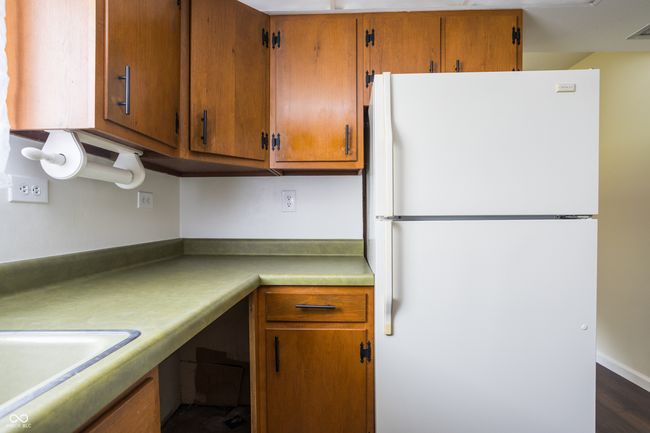 kitchen featuring freestanding refrigerator, brown cabinetry, and light countertops | Image 17