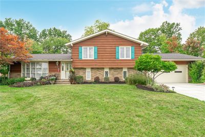 Split level home with a garage and a front lawn | Image 1