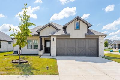 View of front of property featuring a front entry garage and a front yard | Image 1