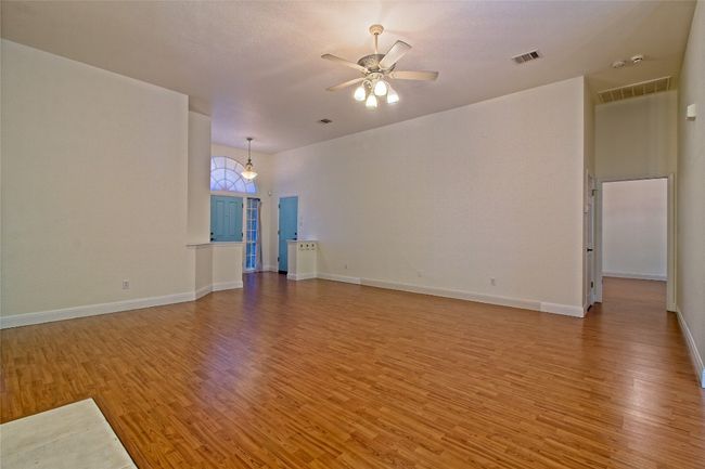 Unfurnished living room with light wood-style flooring and ceiling fan | Image 8
