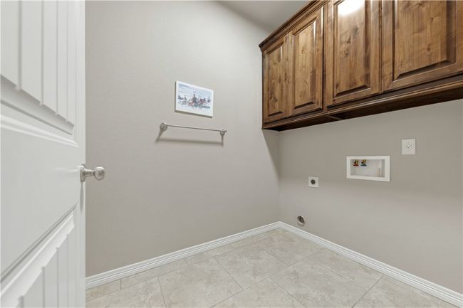 Washroom with cabinet space, hookup for an electric dryer, washer hookup, and baseboards | Image 30