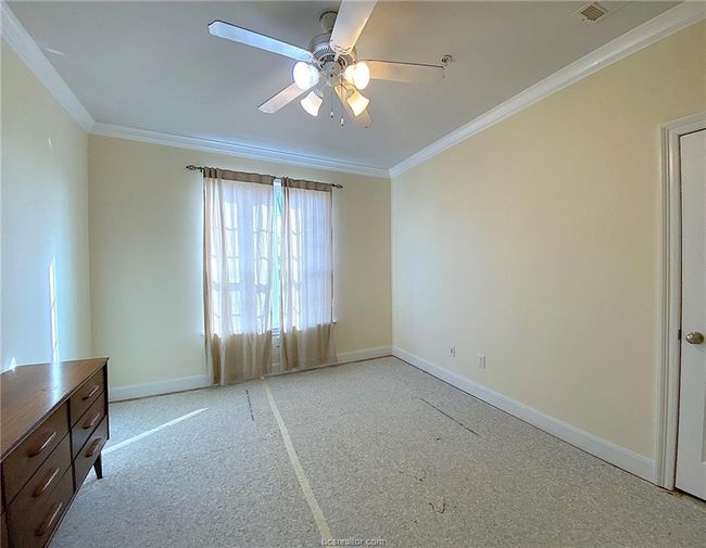 Unfurnished room with baseboards, crown molding, ceiling fan, and light carpet | Image 7