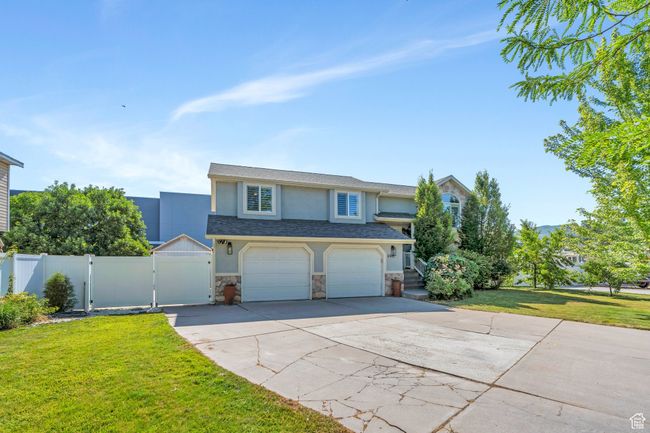 View of front of home featuring a gate, stucco siding, stone siding, concrete driveway, and an attached garage | Image 34